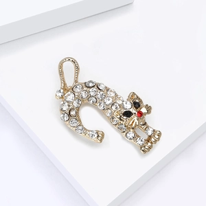 Détail d'une broche chat dorée sertie de strass brillants et d'une pierre rouge
