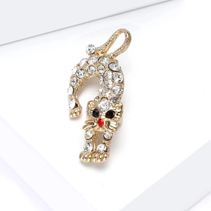 Vue détaillée d'une broche chat dorée avec des strass brillants et des yeux noirs