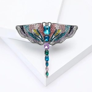 Elegant colorful crystal dragonfly brooch with rhinestone wings on white geometric cubes