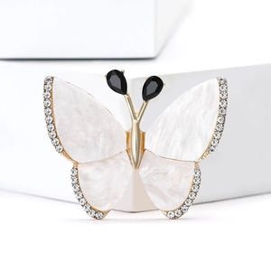 Elegante broche de mariposa dorado con alas blancas y cristales de strass brillantes