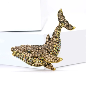 Exquisite gold-tone whale brooch with sparkling champagne rhinestones on white display