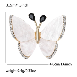 Elegante broche de mariposa con alas de perla blanca y diamantes en base dorada
