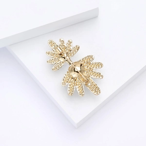 Vue détaillée de l'arrière d'une broche feuille dorée avec fermoir de sécurité sur blanc