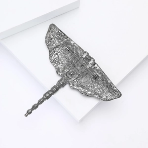 Detailed view of dragonfly brooch pin back with metal texture and secure clasp