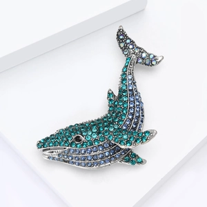 Macro shot of whale brooch featuring gradient blue rhinestones and vintage silver finish