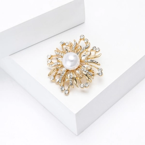 Détail d'une broche fleur de luxe avec perle centrale et strass étincelants