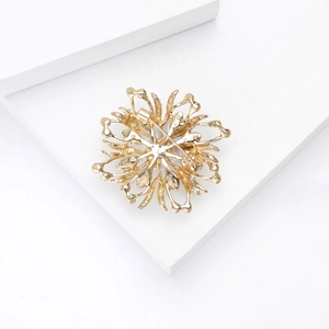 Vue détaillée du dos d'une broche fleur dorée avec épingle de sûreté et structure évidée