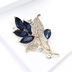 Vue détaillée de la broche orchidée montrant les pierres bleues et le pavé de zircons