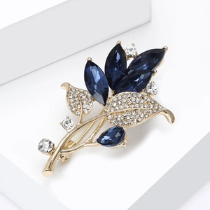 Détail macro de la broche orchidée avec cristaux bleus marquise et alliage doré