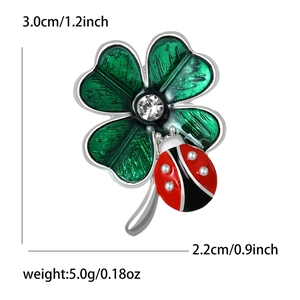 Detail view of enamel clover and ladybug brooch with dimensions 3.0cm by 2.2cm