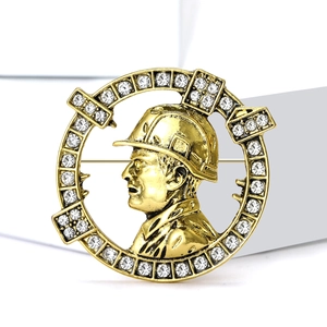 Gold-plated engineer badge with rhinestone rim showing a man in a safety helmet
