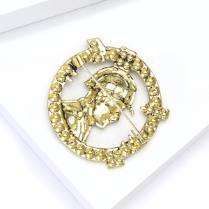 Macro detail of gold vintage round brooch with warrior relief and pin backing