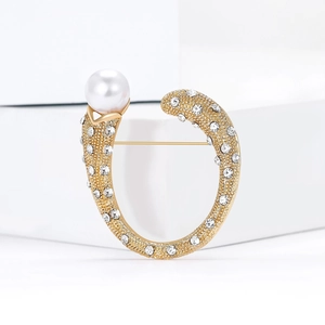 Elegante spilla in lega dorata a forma di U con strass scintillanti e perla raffinata