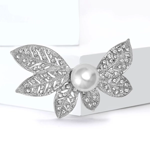 Élégante broche papillon argentée avec strass scintillants et une grande perle blanche