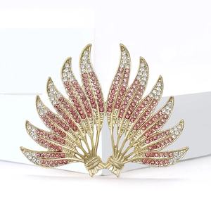 Luxurious gold-tone brooch featuring gradient pink and clear crystals on a wing design
