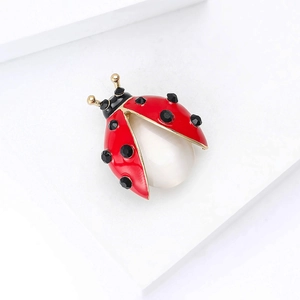 Elegant ladybug brooch with red enamel, black rhinestones, and central white pearl accent