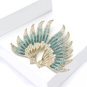Macro shot of luxury gold brooch with blue and white crystals on a white pedestal