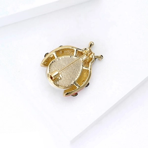 Detailed view of the gold-plated insect brooch back with a secure pin and safety clasp