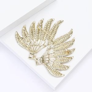 Detail view of the secure metal pin fastener and textured back of the gold wing brooch