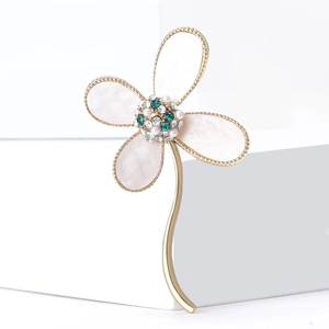Elegant four-leaf clover brooch with abalone shell petals and gold stem on white steps