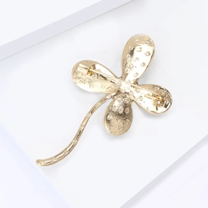 Detailed back view of golden four-leaf clover brooch showing pin clasp mechanism
