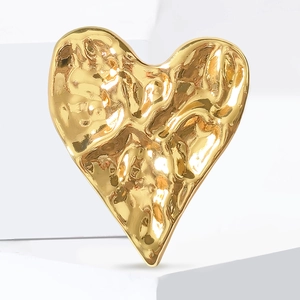 Broche cœur dorée avec texture martelée unique et finition brillante sur socle blanc