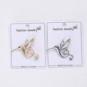 Detail of hummingbird musical note brooches in gold and silver finish on display cards