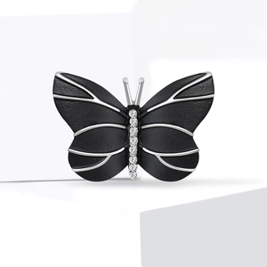 Élégante broche papillon avec ailes noires mates et centre en cristaux étincelants