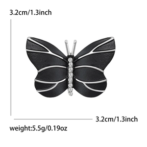 Broche papillon élégante avec ailes noires, nervures argentées et strass brillants