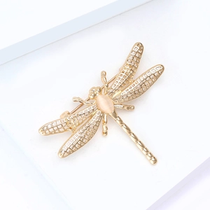 Detailed close-up of a gold alloy dragonfly brooch with hollow wings and yellow opal stone
