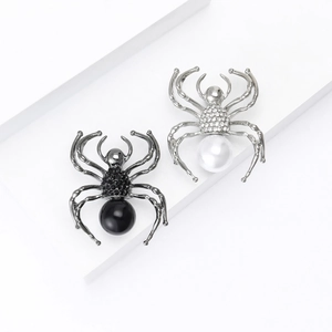 Spider brooch set with sparkling rhinestones and pearls on white geometric display