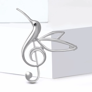 Silver hummingbird music note brooch with polished finish and black gemstone eye accent