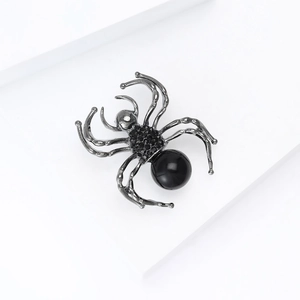 Detailed view of spider brooch featuring gunmetal alloy legs and a large black pearl