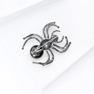 Macro view of the spider brooch back showing metal structure and pin fastener detail