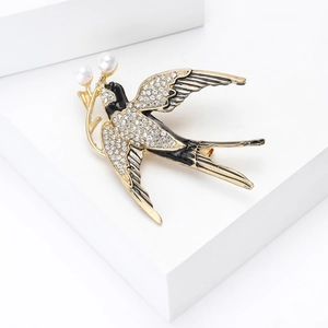 Makro-Detail der Schwalben-Brosche mit Strass, schwarzer Emaille und weißen Perlen
