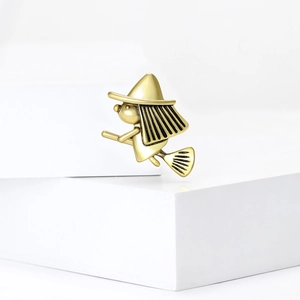 Retro goudkleurige legering heks op bezemsteel broche op witte geometrische stands