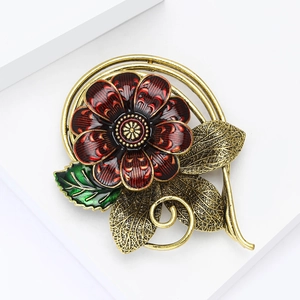 Vintage enamel red flower brooch with gold leaves on a white minimalist display stand