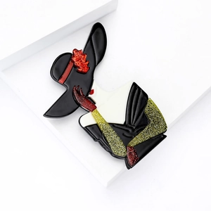 Art Deco acrylic Marilyn Monroe brooch with red and gold sequins on a white background