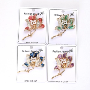 Set dettagliato di quattro spille a fiori in smalto con perle e strass in espositore