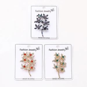 Detailed view of rhinestone floral branch brooches in purple, red, and green colors