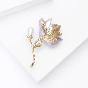 Detailed back view of the floral enamel brooch with golden safety pin and metal texture