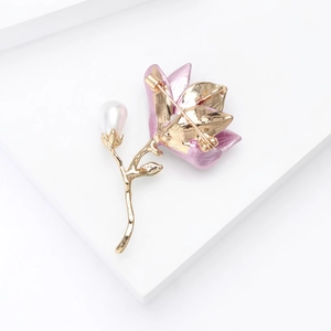 Detail view showing the secure pin clasp and gold alloy finish on a floral pearl brooch
