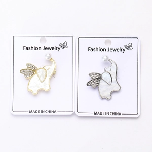 Detailed macro view of gold and silver elephant brooches with shell and pearls