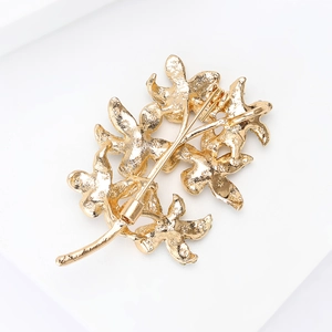 Detailed back view of gold branch brooch with textured alloy finish and secure pin clasp