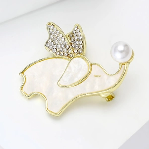 Close-up of golden elephant brooch with mother of pearl shell and sparkling crystal wings