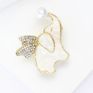 Detailed close-up of golden elephant brooch with mother of pearl shell and pearl accent