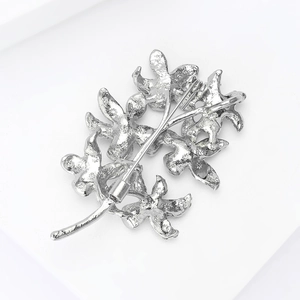 Detailed back view of a silver floral brooch showing the pin clasp and metallic texture
