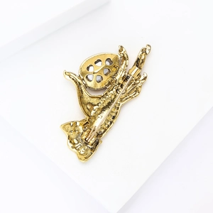 Detail view showing the sturdy golden metal back and pin closure of the hand-shaped brooch