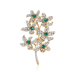 Broche élégante en forme de branche dorée avec diamants blancs et gemmes vertes