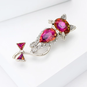 Close-up of pink and orange gradient rhinestones on a silver cat-shaped brooch